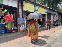 A woman is using an umbrella to protect herself from the hot sun in Thiruvananthapuram (Trivandrum), Kerala, India, on March 31, 2024. (