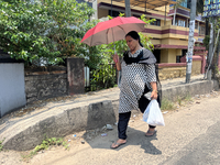 A woman is using an umbrella to protect herself from the hot sun in Thiruvananthapuram (Trivandrum), Kerala, India, on March 31, 2024. (