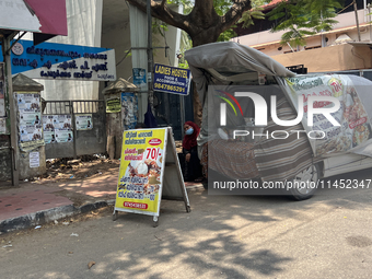 A woman is selling pre-made biryani from the back of a vehicle along the roadside in Thiruvananthapuram (Trivandrum), Kerala, India, on Marc...