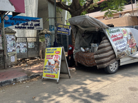 A woman is selling pre-made biryani from the back of a vehicle along the roadside in Thiruvananthapuram (Trivandrum), Kerala, India, on Marc...