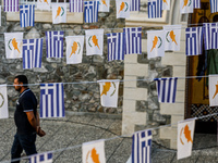 A man is walking in the monastery yard under Greek and Cypriot flags in Kykkos, Cyprus, on August 4, 2024. President of Cyprus Nikos Christo...