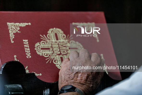 The hand of an elderly man is being seen during the service in Kykkos, Cyprus, on August 4, 2024. President of Cyprus Nikos Christodoulides...