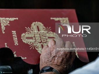 The hand of an elderly man is being seen during the service in Kykkos, Cyprus, on August 4, 2024. President of Cyprus Nikos Christodoulides...