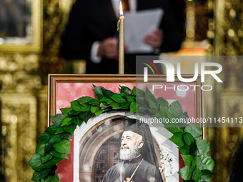 Minister of Labour Yiannis Panayiotou is giving his speech during the service behind the photograph of Makarios in Kykkos, Cyprus, on August...