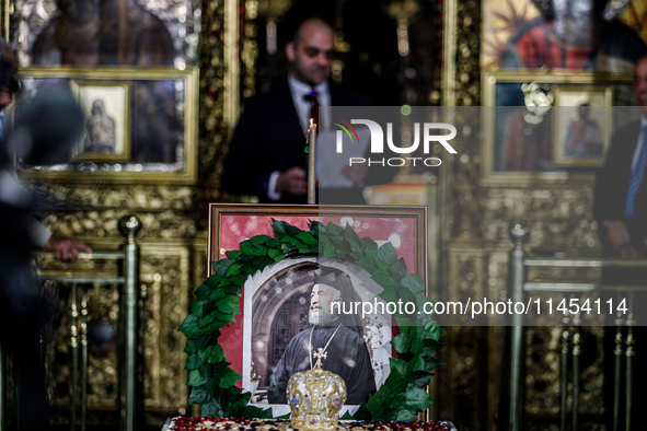 Minister of Labour Yiannis Panayiotou is giving his speech during the service behind the photograph of Makarios in Kykkos, Cyprus, on August...