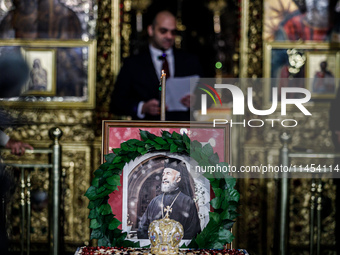 Minister of Labour Yiannis Panayiotou is giving his speech during the service behind the photograph of Makarios in Kykkos, Cyprus, on August...