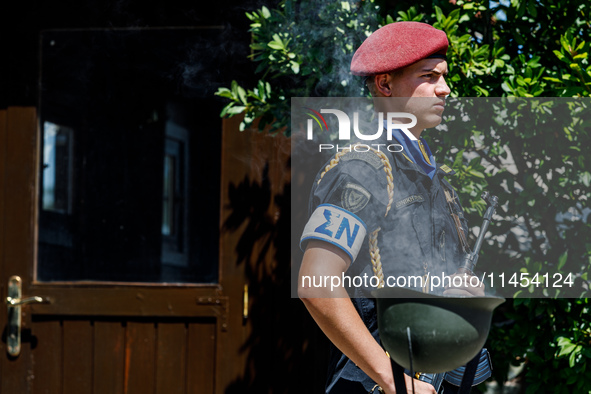 A soldier is standing behind smoke coming from a helmet in front of the Makarios statue in Kykkos, Cyprus, on August 4, 2024. President of C...