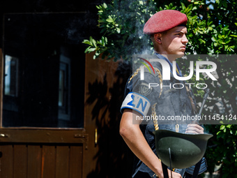 A soldier is standing behind smoke coming from a helmet in front of the Makarios statue in Kykkos, Cyprus, on August 4, 2024. President of C...