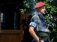 A soldier is standing behind smoke coming from a helmet in front of the Makarios statue in Kykkos, Cyprus, on August 4, 2024. President of C...