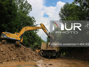 An excavator is removing debris after a cloudburst near Cherwan Padabal area in central Kashmir's Ganderbal district, some 42 kilometers fro...