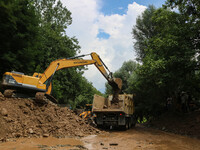 An excavator is removing debris after a cloudburst near Cherwan Padabal area in central Kashmir's Ganderbal district, some 42 kilometers fro...