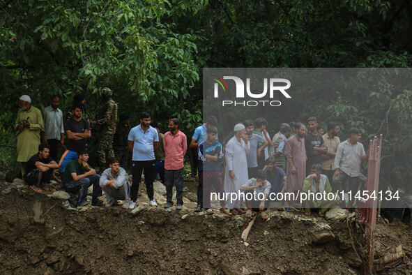 People are standing on debris after a cloudburst near Cherwan Padabal area in central Kashmir's Ganderbal district, some 42 kilometers from...