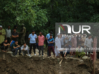 People are standing on debris after a cloudburst near Cherwan Padabal area in central Kashmir's Ganderbal district, some 42 kilometers from...