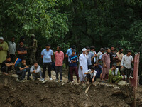 People are standing on debris after a cloudburst near Cherwan Padabal area in central Kashmir's Ganderbal district, some 42 kilometers from...