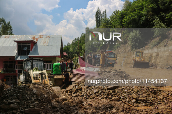 People are standing on debris after a cloudburst near Cherwan Padabal area in central Kashmir's Ganderbal district, some 42 kilometers from...