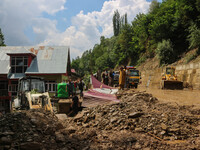 People are standing on debris after a cloudburst near Cherwan Padabal area in central Kashmir's Ganderbal district, some 42 kilometers from...