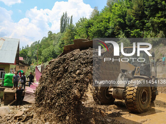 An excavator is removing debris after a cloudburst near Cherwan Padabal area in central Kashmir's Ganderbal district, some 42 kilometers fro...