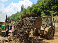 An excavator is removing debris after a cloudburst near Cherwan Padabal area in central Kashmir's Ganderbal district, some 42 kilometers fro...