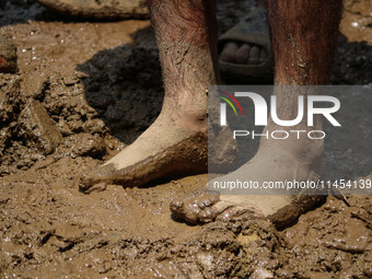 A man is standing in the mud after a cloudburst near Cherwan Padabal area in central Kashmir's Ganderbal district, some 42 kilometers from S...