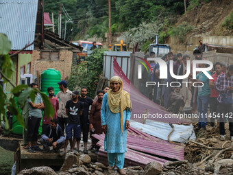 A Kashmiri woman is standing on debris after a cloudburst near Cherwan Padabal area in central Kashmir's Ganderbal district, some 42 kilomet...