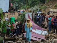 A Kashmiri woman is standing on debris after a cloudburst near Cherwan Padabal area in central Kashmir's Ganderbal district, some 42 kilomet...