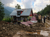 People are standing on debris after a cloudburst near Cherwan Padabal area in central Kashmir's Ganderbal district, some 42 kilometers from...