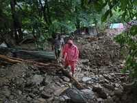 People are walking over the debris after a cloudburst near Cherwan Padabal area in central Kashmir's Ganderbal district, some 42 kilometers...