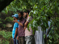 People are looking on as excavators are removing debris after a cloudburst near Cherwan Padabal area in central Kashmir's Ganderbal district...