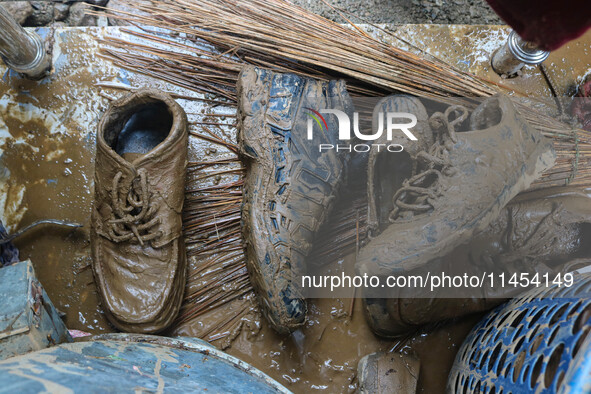 Shoes covered with mud are being seen after a cloudburst near Cherwan Padabal area in central Kashmir's Ganderbal district, some 42 kilomete...