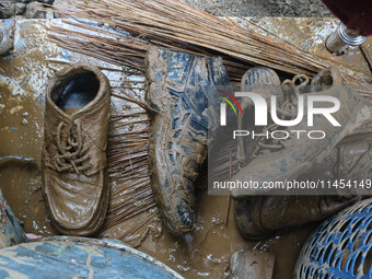 Shoes covered with mud are being seen after a cloudburst near Cherwan Padabal area in central Kashmir's Ganderbal district, some 42 kilomete...