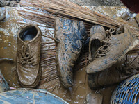 Shoes covered with mud are being seen after a cloudburst near Cherwan Padabal area in central Kashmir's Ganderbal district, some 42 kilomete...