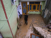 A man is standing in the mud after a cloudburst near Cherwan Padabal area in central Kashmir's Ganderbal district, some 42 kilometers from S...