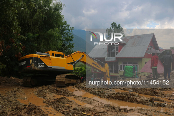 An excavator is removing debris after a cloudburst near Cherwan Padabal area in central Kashmir's Ganderbal district, some 42 kilometers fro...