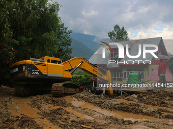 An excavator is removing debris after a cloudburst near Cherwan Padabal area in central Kashmir's Ganderbal district, some 42 kilometers fro...