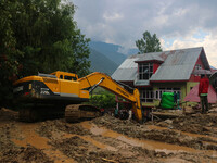 An excavator is removing debris after a cloudburst near Cherwan Padabal area in central Kashmir's Ganderbal district, some 42 kilometers fro...