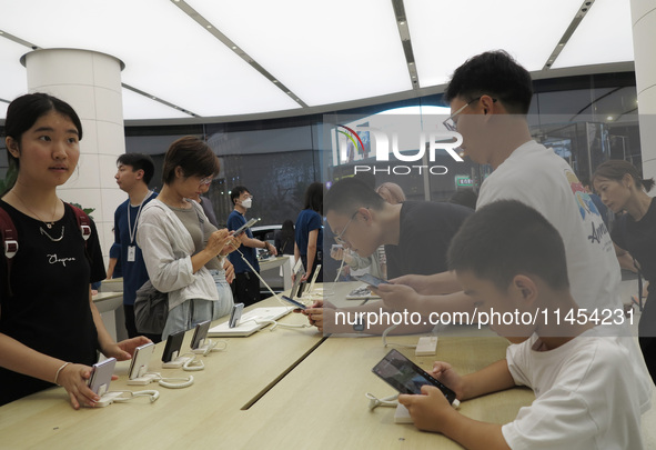 People are experiencing Huawei mobile phones at the Huawei store in Wangfujing, Beijing, China, on August 4, 2024. 