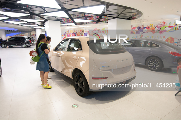 People are checking on a SAIC Volkswagen auto as 70 models of auto dealers from Tesla, Audi, Hongqi, SAIC Volkswagen, and Jiyue Nio are on d...