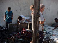 Palestinians are inspecting the site of an Israeli strike on a tent camp for displaced people, amid the Israel-Hamas conflict, in Deir Al-Ba...