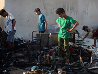 Palestinians are inspecting the site of an Israeli strike on a tent camp for displaced people, amid the Israel-Hamas conflict, in Deir Al-Ba...