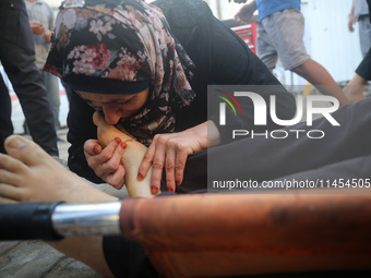 (EDITOR'S NOTE: Graphic content) A Palestinian woman is bidding farewell to a member of her family in the aftermath of a reported overnight...