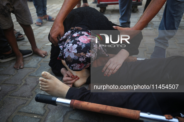 (EDITOR'S NOTE: Graphic content) A Palestinian woman is bidding farewell to a member of her family in the aftermath of a reported overnight...