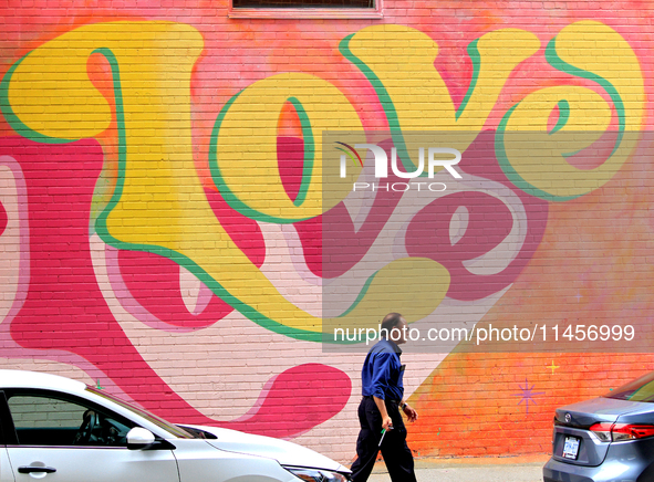 A Brampton Transit employee is walking in front of a colourful mural at the downtown Brampton, Ontario, transit terminal on Monday, August 5...