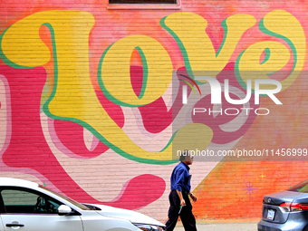 A Brampton Transit employee is walking in front of a colourful mural at the downtown Brampton, Ontario, transit terminal on Monday, August 5...