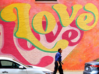 A Brampton Transit employee is walking in front of a colourful mural at the downtown Brampton, Ontario, transit terminal on Monday, August 5...