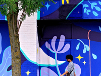 A person is walking in front of a colorful mural near the downtown Brampton, Ontario, transit terminal on Monday, August 5, 2024. (