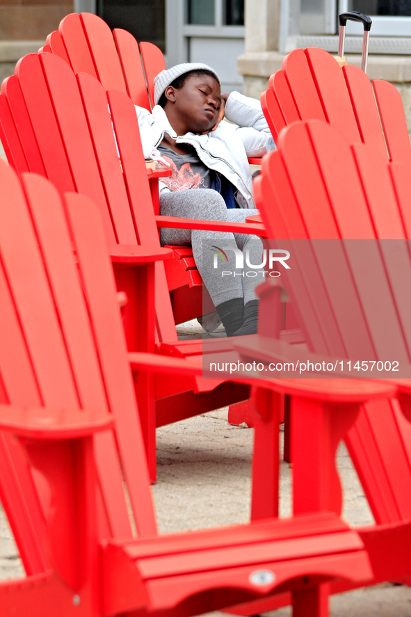 A person is napping on seating in Garden Square in downtown Brampton, Ontario, on August 5, 2024. 