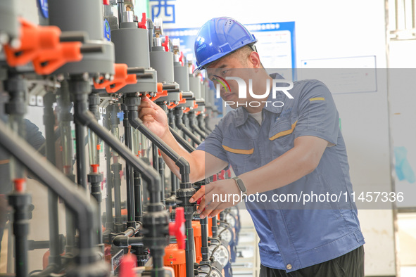 Workers are inspecting various water supply equipment at Qinghong Water Plant in Qianyuan town, Deqing County, Huzhou city, Zhejiang provinc...