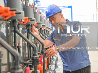 Workers are inspecting various water supply equipment at Qinghong Water Plant in Qianyuan town, Deqing County, Huzhou city, Zhejiang provinc...