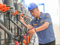 Workers are inspecting various water supply equipment at Qinghong Water Plant in Qianyuan town, Deqing County, Huzhou city, Zhejiang provinc...