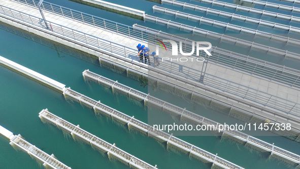 Workers are inspecting various water supply equipment at Qinghong Water Plant in Qianyuan town, Deqing County, Huzhou city, Zhejiang provinc...